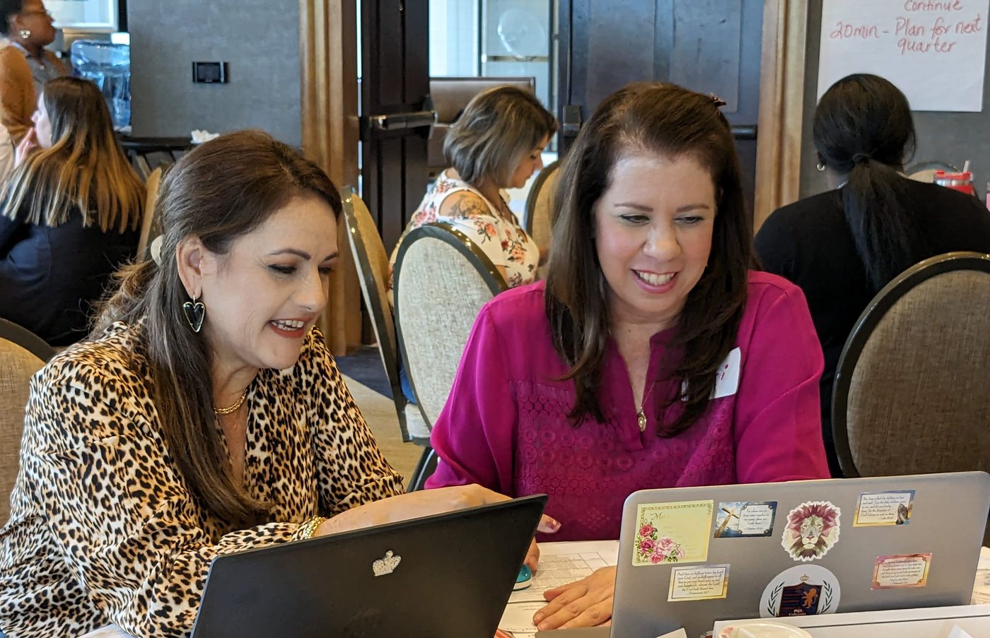 Two educators working side by side at their laptops during a planning session